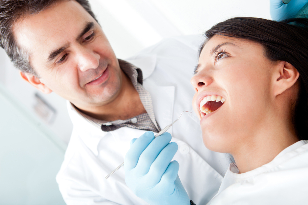 Dentist working on a female patient at his practice