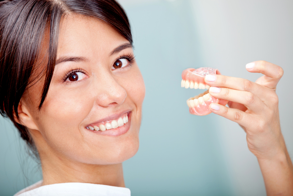 Woman holding a teeth sample or prosthesis at the dentist-4